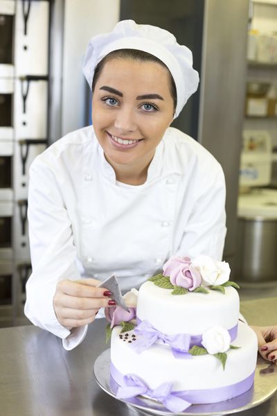 Baker decorates a cake with food dye