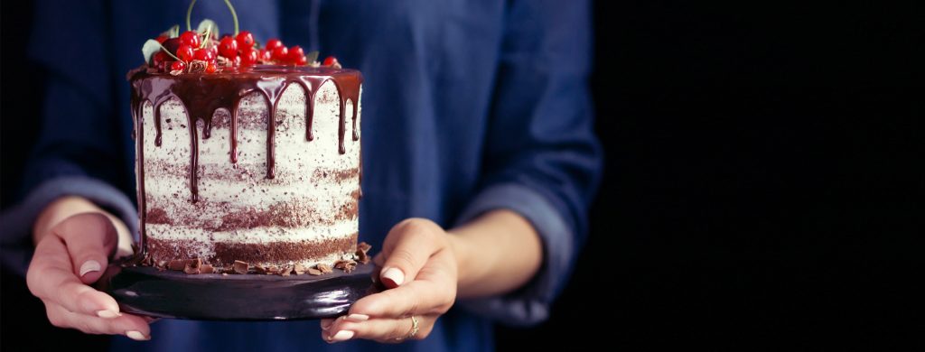 A woman in a blue shirt holding a fruit cake, cover template for social networks
